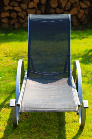 Relax  Empty black deck chair on the green grass in the garden  Spring or summer  Outdoor 