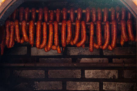 Traditional food. Smoked sausages meat hanging in domestic smokehouse.の写真素材