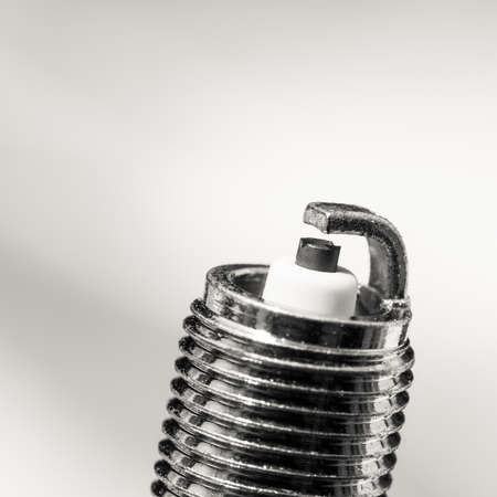 Auto service. New car spark plug as spare part of auto transportation on gray background.の写真素材