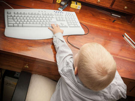 Smart little boy child kid playing on the desktop computer at home. の写真素材