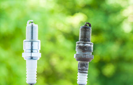 Auto service  Two car spark plugs new and old as spare part of auto transportationの写真素材