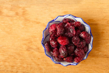 Healthy food organic nutrition. dried cranberries cranberry fruit in bowl on wooden table background