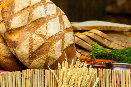 many rustic baked traditional rye bread loaves on a market stall outdoorの写真素材