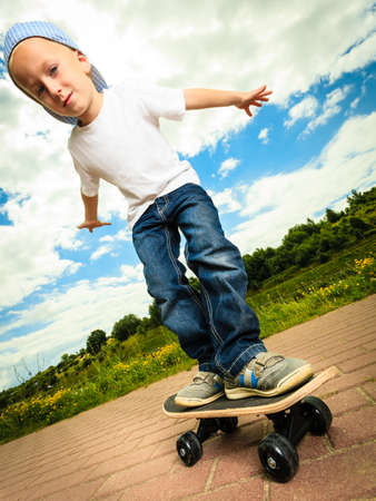 Active childhood. Little man skateboarding. Skater boy child kid with his skateboard. Outdoor.の写真素材