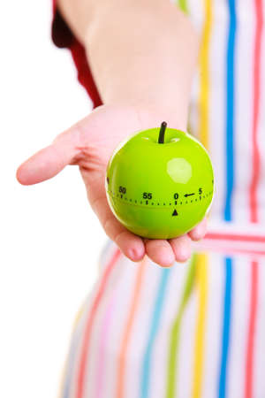 Closeup of female hands. Housewife or chef in colorful kitchen using apple timer eggtimer isolated studio shotの写真素材