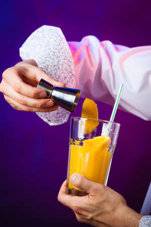 Young stylish man bartender preparing serving alcohol cocktail drinkの写真素材