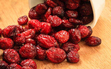 Healthy high fiber foods, organic nutrition. Close up dried cranberries cranberry fruit in bowl on wooden table.の写真素材