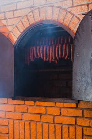 Traditional food. Smoked sausages meat hanging in domestic smokehouse.の写真素材