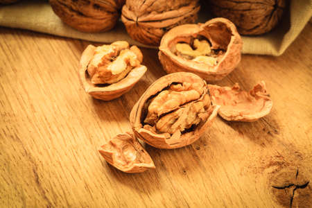 Healthy food full of omega-3 fatty acids, organic nutrition. Walnut kernels and whole on rustic old...