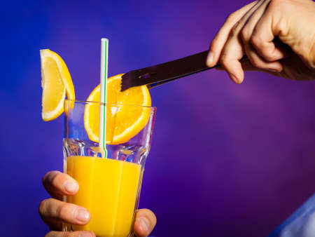 Young stylish man bartender preparing serving alcohol cocktail drinkの写真素材