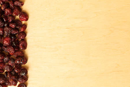 Healthy food organic nutrition. Border frame of dried cranberries cranberry fruit on wooden...