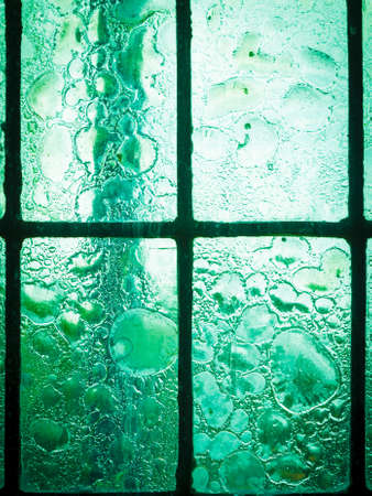 stained glass window with regular block pattern in hue of greenの写真素材