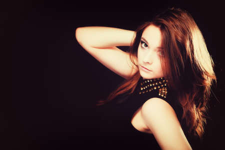 Young people teenage concept - pensive serious woman portrait, fashion teenager girl wearing blouse with gold metal stud on blackの写真素材