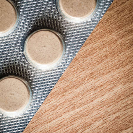 Medical background backdrop with pills tablets drugs on wooden table. Pharmacy.の写真素材