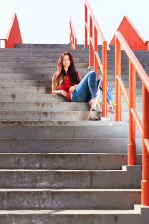 Summer sport and active lifestyle. Cool teenage girl skater with skateboard on the stairs. Outdoor.の写真素材