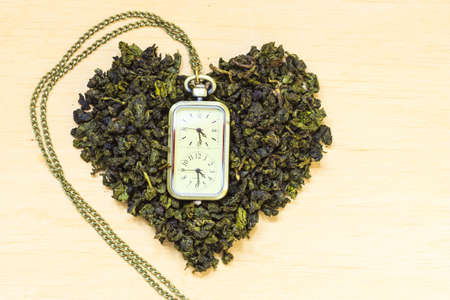 Diet healthcare tea time concept. Green tea heart shaped on wooden surface. Healthy food drink for...