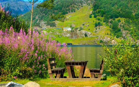 Picnic site wooden table and benches near lake in Norway, Europe.の写真素材