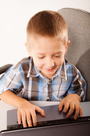 Education, school, technology and internet concept - little student boy with laptop pc computer