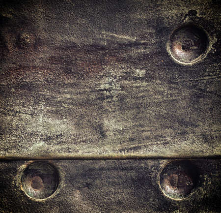Closeup of grunge black metal plate with rivets and screws as background or texture. Square format.の写真素材