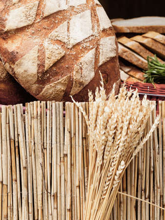 many rustic baked traditional rye bread loaves on a market stall outdoorの写真素材