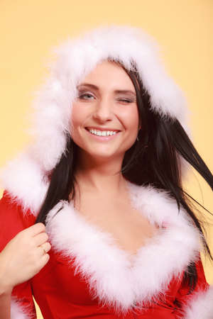 Beautiful sexy woman wearing santa claus costume clothes on yellow backgroundの写真素材
