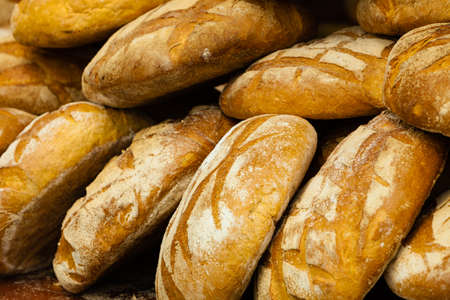 many rustic baked traditional rye bread loaves on a market stall outdoor
