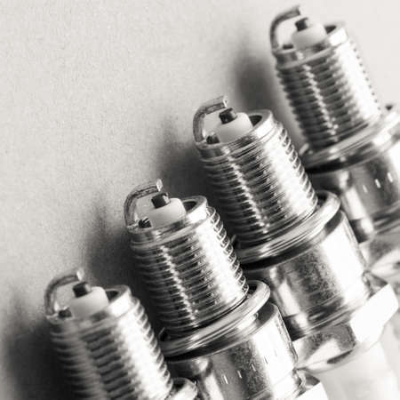 Auto service. Set of new car spark plugs as spare part of auto transportation on grayの写真素材