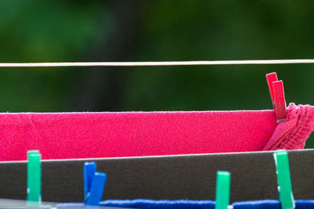 Housework. Clean wet laundry clothes hanging to dry on the line clothesline outdoor. Rural scene.の写真素材