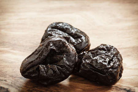 Healthy food, good cuisine. Closeup dried plums prunes fruits on wooden rustic table backgroundの写真素材