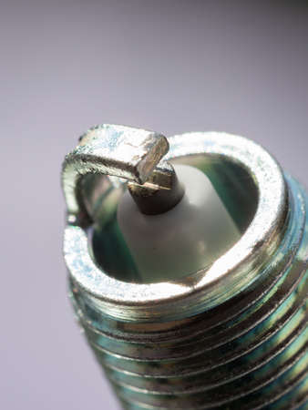 Auto service. New car spark plug as spare part of auto transportation on gray background.の写真素材