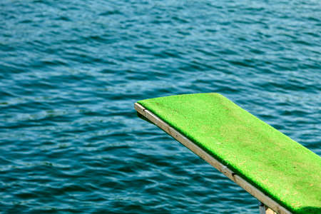 Summer vacation and dangerous sport. View of diving board. Springboard to dive at water.の写真素材