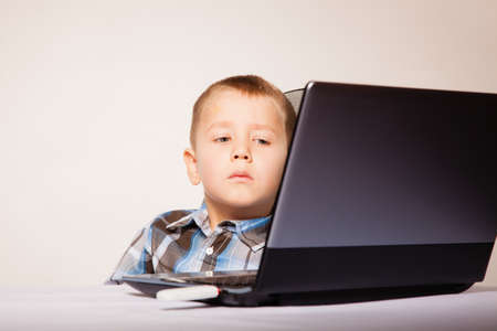 Education, school, technology and internet concept - little student boy with laptop pc computerの写真素材