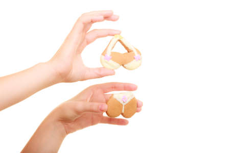 Summer fashion. Girl holding bikini shaped cookie, studio shot isolatedの写真素材