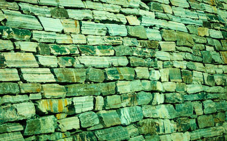 Background of natural stone rock wall texture. Green toneの写真素材