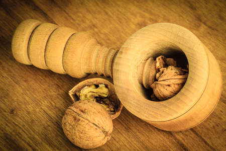 Healthy food full of omega-3 fatty acids, organic nutrition. Closeup walnut and nutcracker on rustic...