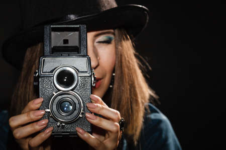 Steampunk. Retro woman with old vintage camera studio shot grunge dark backgroundの写真素材