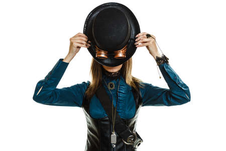 beautiful elegant steampunk retro woman covering her face with black hat studio shot isolated on white backgroundの写真素材