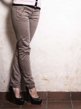 Closeup of female legs in fashionable black high heels and blank copy space on empty white wall. Female fashion.の写真素材