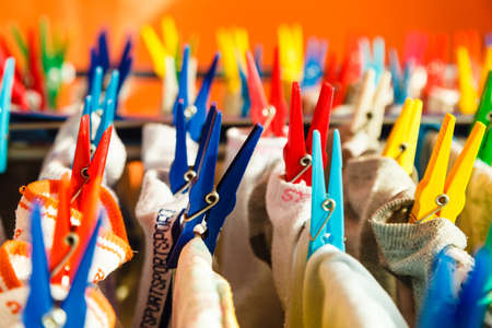Housework concept. Closeup clothes hanging to dry on a laundry line with colorful pegs clips indoorの写真素材