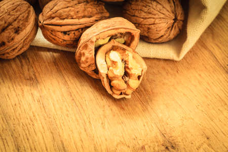 Healthy food full of omega-3 fatty acids, organic nutrition. Walnut kernels and whole on rustic old...
