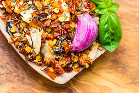 Good cuisine. Closeup colored spices for pasta mix and fresh basil leaf on wooden spoonの写真素材