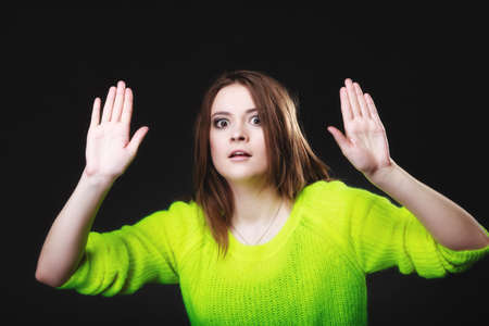 Scared. young woman teen girl making stop gesture sign with hands palms on black.の写真素材