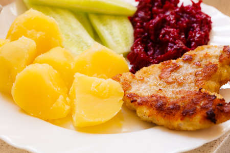 Dinner meal. Fried chicken meat potatos and vegetables salad on plate.の写真素材