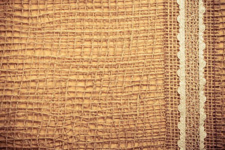Lace frame on natural mesh material, brown burlap cloth background. Retro vintage styleの写真素材