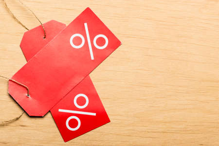 Shopping and sale concept. Red price labels with percent sign on wooden surface background. Copyspaceの写真素材