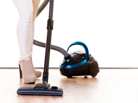 Woman vacuuming the house, female legs with vacuum cleaner. Houseworkの写真素材