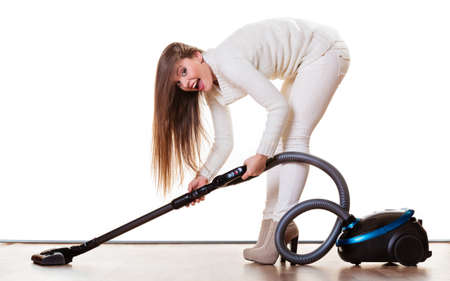 Woman vacuuming the house. Funny girl with vacuum cleaner. Houseworkの写真素材