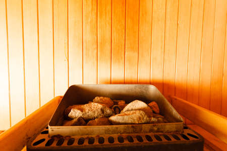 Beauty health spa and lifestyle concept. Interior of wooden finnish sauna, hot stones for steam,...