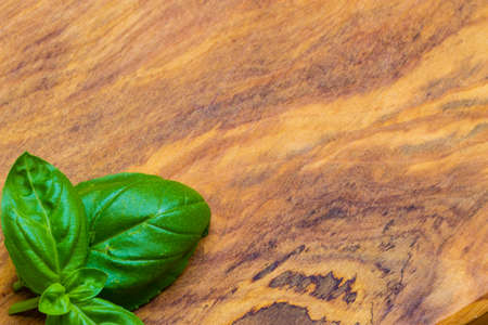 Aromatic spice. Fresh green basil leaves on rustic wooden table background. Copy space.の写真素材