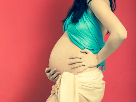 New life concept. Pregnancy, motherhood and happiness. Closeup tummy of pregnant woman wearing blue...